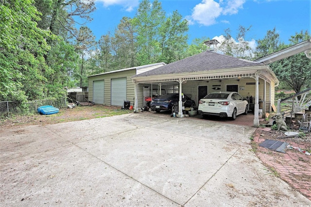 view of car parking with fence and a carport