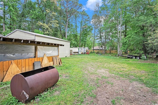 view of grassy yard featuring view of wooded area