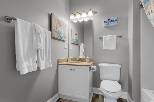 full bath featuring wood finished floors, toilet, baseboards, and vanity
