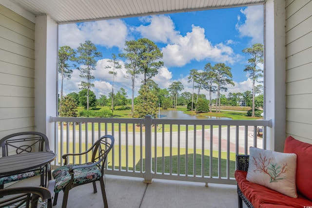 balcony featuring a water view and view of scattered trees