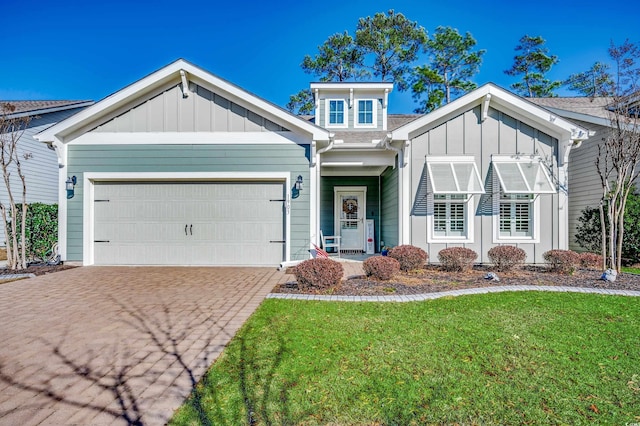 view of front of home with board and batten siding, driveway, a garage, and a front lawn
