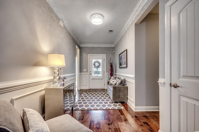 foyer featuring dark wood-type flooring, crown molding, and a wainscoted wall