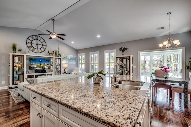 kitchen featuring a sink, a chandelier, open floor plan, dark wood-style flooring, and an island with sink