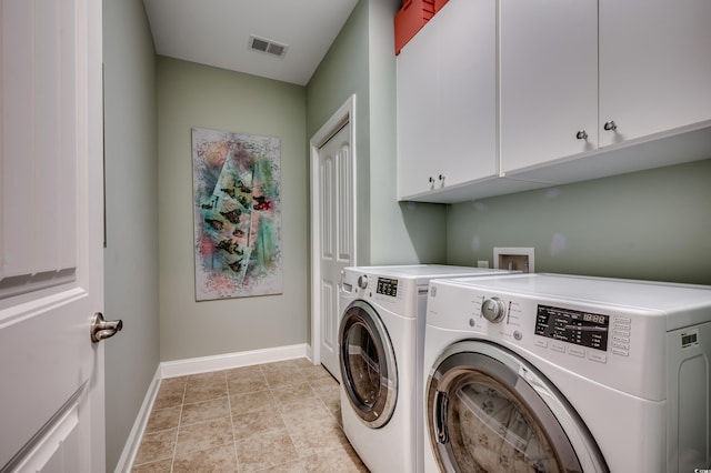 clothes washing area with cabinet space, washer and dryer, and baseboards