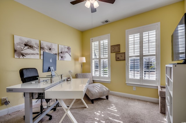 carpeted office with ceiling fan and baseboards