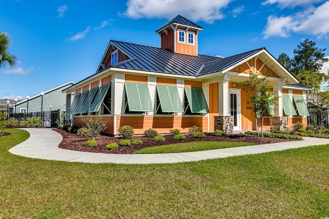 view of front facade featuring a standing seam roof, metal roof, board and batten siding, and stone siding