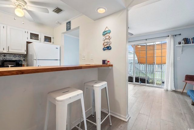 3008 Church St Unit D3, Myrtle Beach, SC 29577 - kitchen featuring freestanding refrigerator, black microwave, white cabinets, light wood-style floors, and baseboards