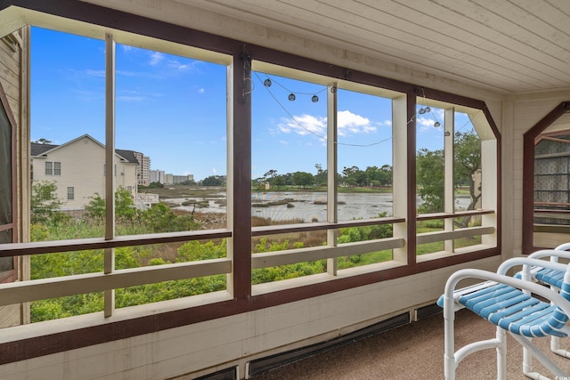 sunroom / solarium with a water view, wooden ceiling, and carpet