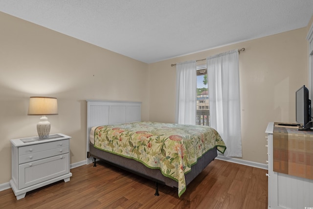 bedroom featuring wood finished floors and baseboards