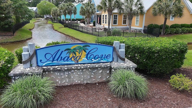 community sign with fence and a water view
