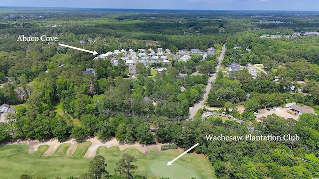 aerial overview of property's location featuring a heavily wooded area and a golf course