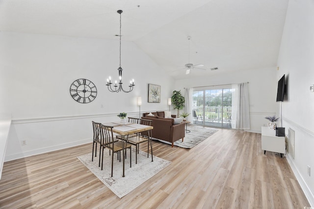 dining room featuring light wood-style floors, high vaulted ceiling, ceiling fan, and a chandelier