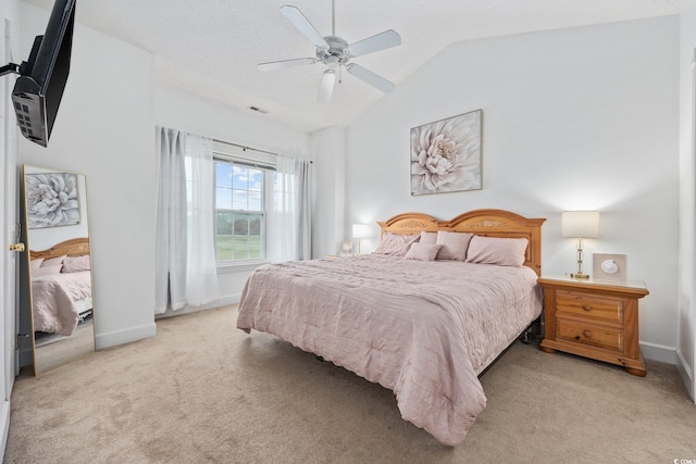 bedroom featuring light carpet, vaulted ceiling, baseboards, and ceiling fan
