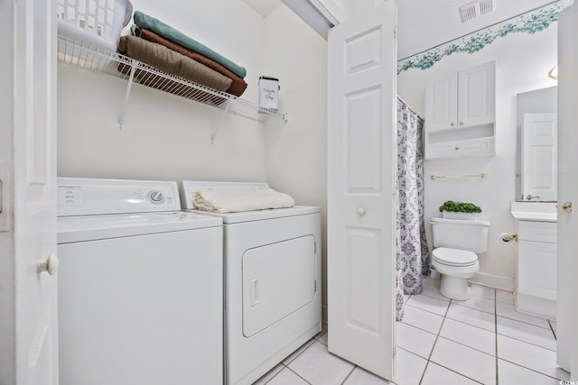 washroom with washer and clothes dryer and light tile patterned floors