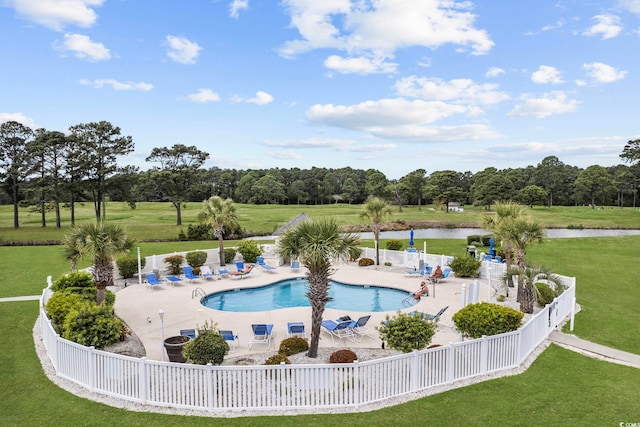 community pool featuring a patio, a water view, and view of wooded area