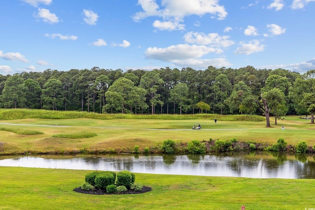 view of home's community with a water view, a yard, and view of golf course