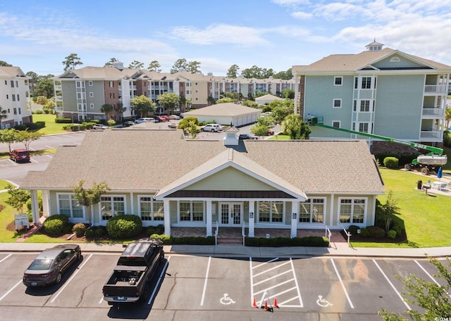 view of building exterior featuring uncovered parking and a residential view