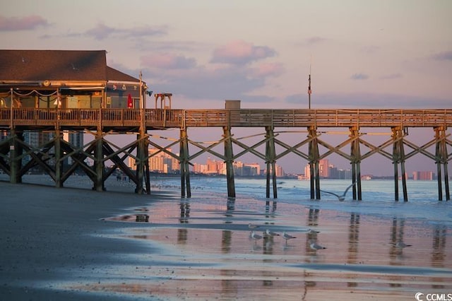 surrounding community with a pier and a water view