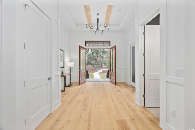 341 Brickwell Ln, Pawleys Island, SC 29585 - hallway with a chandelier, beamed ceiling, light wood-style floors, and a decorative wall