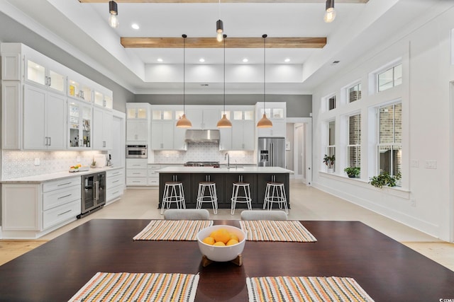 341 Brickwell Ln, Pawleys Island, SC 29585 - kitchen featuring wine cooler, a towering ceiling, appliances with stainless steel finishes, a center island with sink, and tasteful backsplash