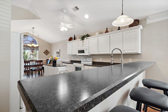 347 Kessinger Dr, Surfside Beach, SC 29575 - kitchen with white appliances, dark countertops, ceiling fan, a peninsula, and white cabinets