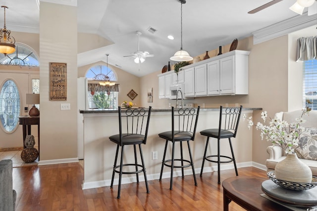 347 Kessinger Dr, Surfside Beach, SC 29575 - kitchen featuring ceiling fan, white microwave, a peninsula, white cabinetry, and wood finished floors