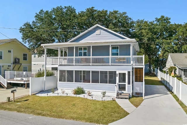 view of front facade with a balcony, concrete driveway, and a sunroom