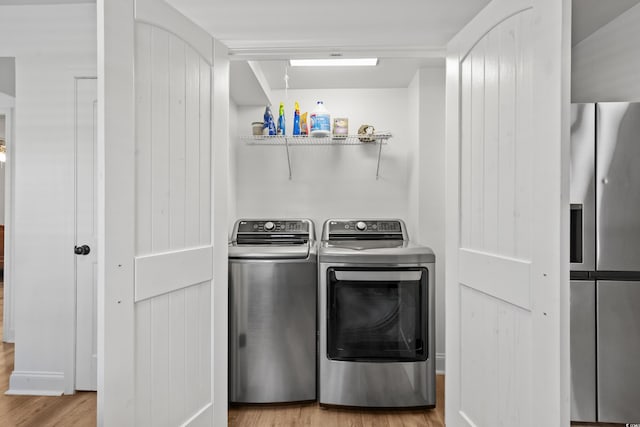 washroom featuring washing machine and clothes dryer and wood finished floors