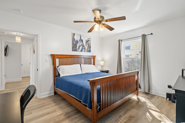 bedroom with wood finished floors, baseboards, and a ceiling fan