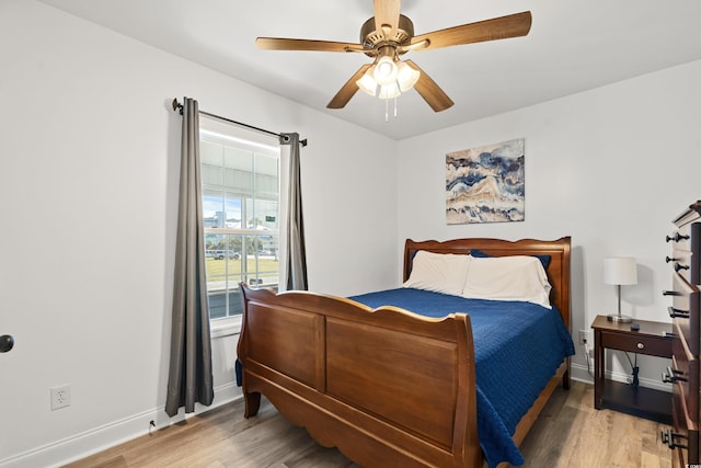 bedroom with wood finished floors, baseboards, and a ceiling fan