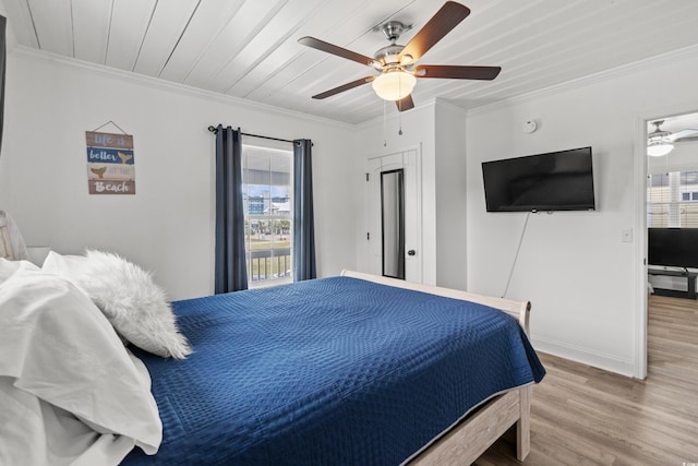 bedroom with wood finished floors, ornamental molding, baseboards, and ceiling fan