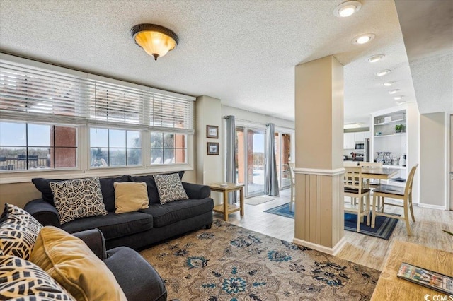 living room with a textured ceiling and light wood finished floors