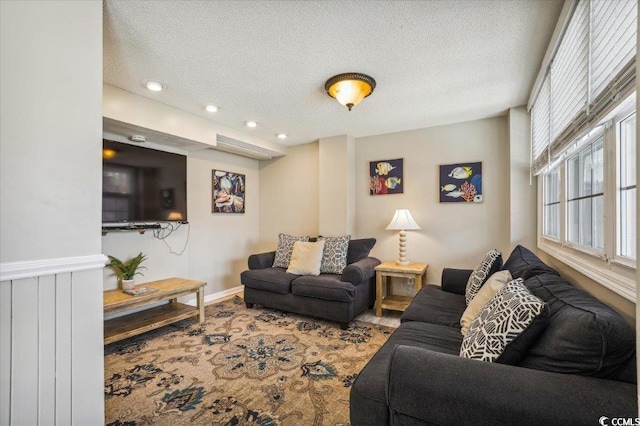 living area with a textured ceiling, recessed lighting, baseboards, and carpet