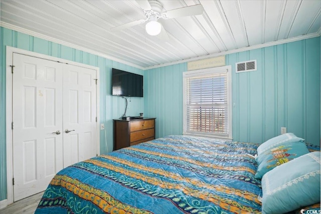 bedroom featuring ornamental molding, wood finished floors, a closet, and a ceiling fan