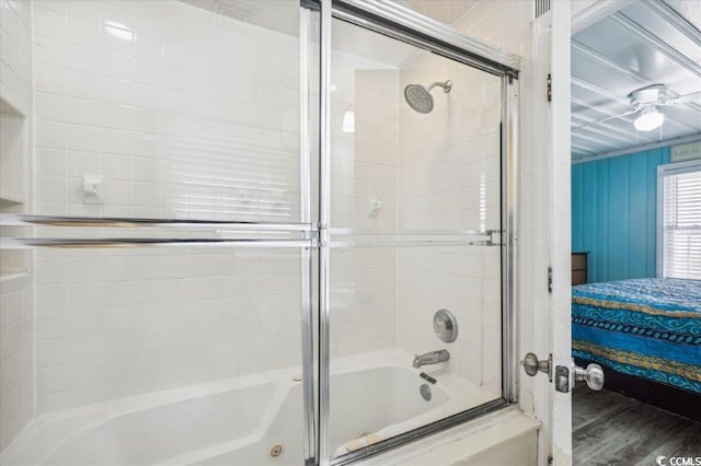 ensuite bathroom featuring enclosed tub / shower combo and wood finished floors