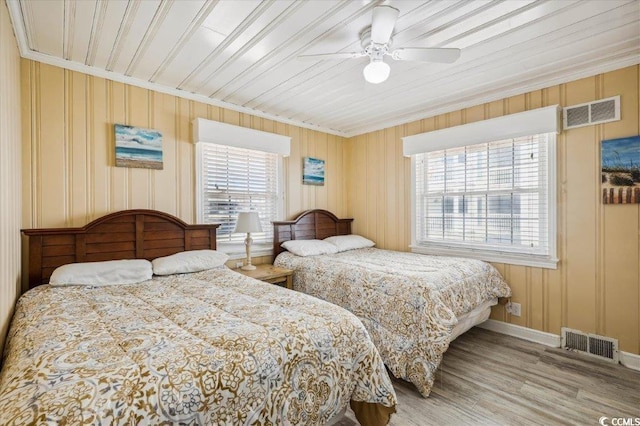 bedroom featuring ornamental molding, wood finished floors, baseboards, and ceiling fan