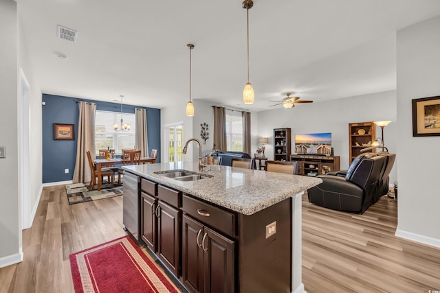kitchen featuring a sink, plenty of natural light, light wood-style floors, and dishwasher