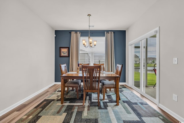 dining room with wood finished floors, a chandelier, and baseboards
