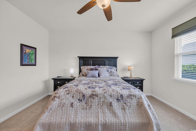 bedroom with light carpet, baseboards, and a ceiling fan