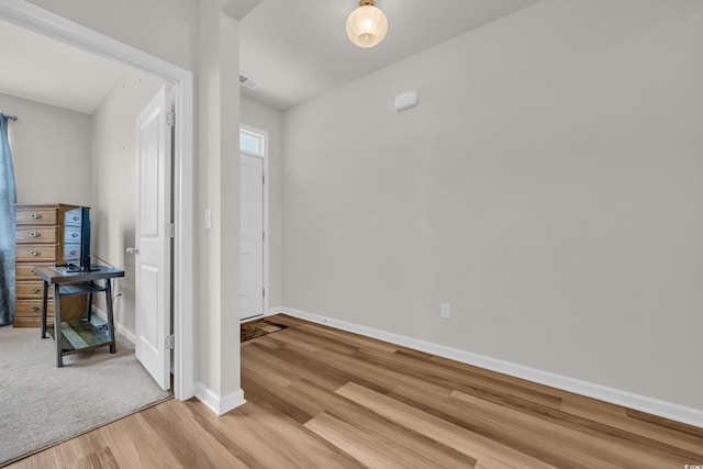 unfurnished bedroom with light wood-style flooring and baseboards