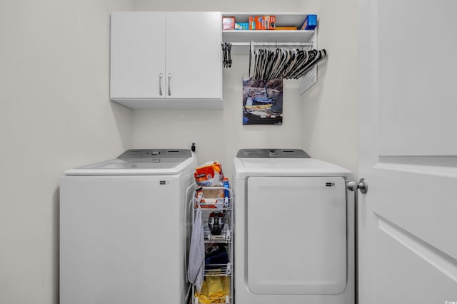laundry room featuring washing machine and dryer and cabinet space