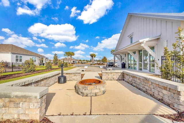view of patio / terrace featuring a fire pit, a residential view, and fence