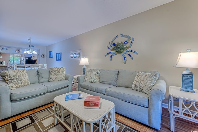 living room featuring wood finished floors and a chandelier
