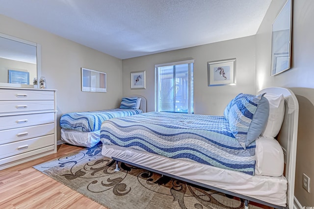 bedroom with wood finished floors and a textured ceiling