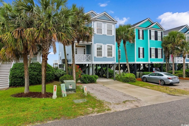 17 N Seaside Dr, Surfside Beach, SC 29575 - coastal inspired home with a carport, concrete driveway, and a front yard