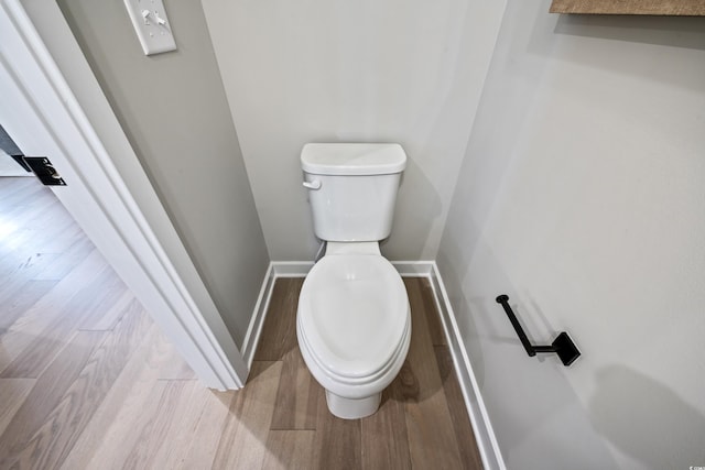 bathroom featuring toilet, wood finished floors, and baseboards