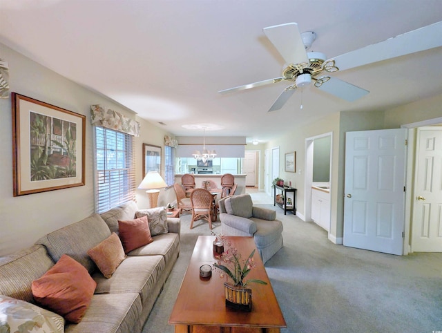 living area with a chandelier, light colored carpet, a ceiling fan, and baseboards