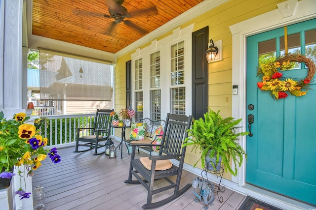 wooden terrace featuring covered porch and ceiling fan