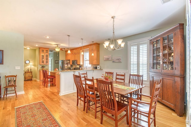dining space with light wood finished floors, a chandelier, recessed lighting, and a ceiling fan