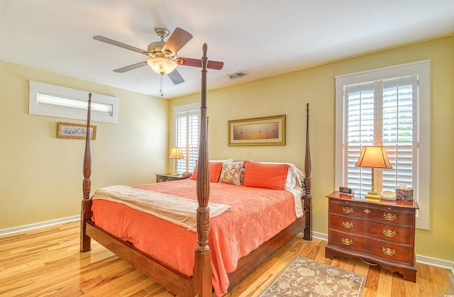 bedroom with light wood finished floors, baseboards, and a ceiling fan